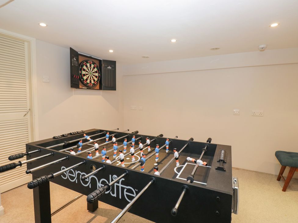 A game room with a foosball table and dartboard at Norwood House in Ambleside