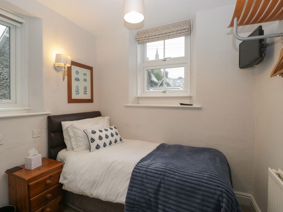 A bedroom with a single bed and artwork on the wall at Norwood House in Ambleside