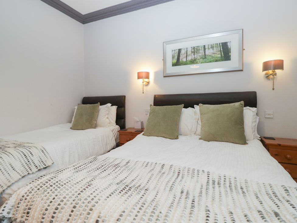 A bedroom with two beds and bedside tables at Norwood House in Ambleside