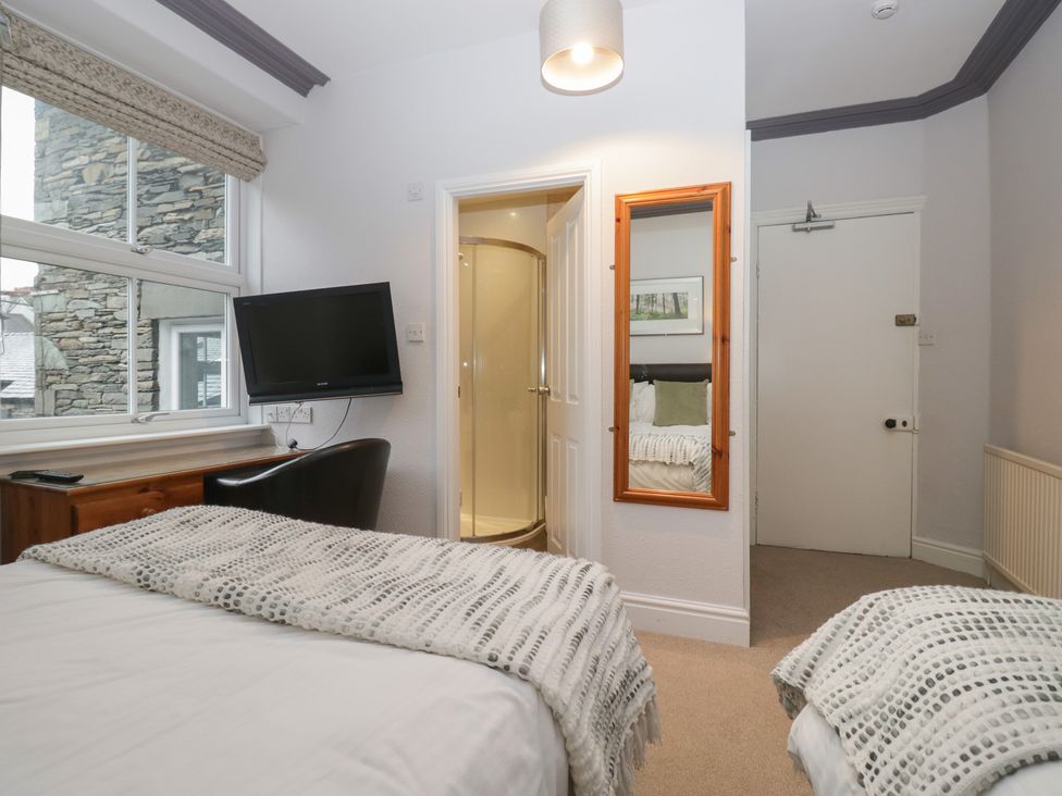 A bedroom with a bed, television, and shower at Norwood House in Ambleside