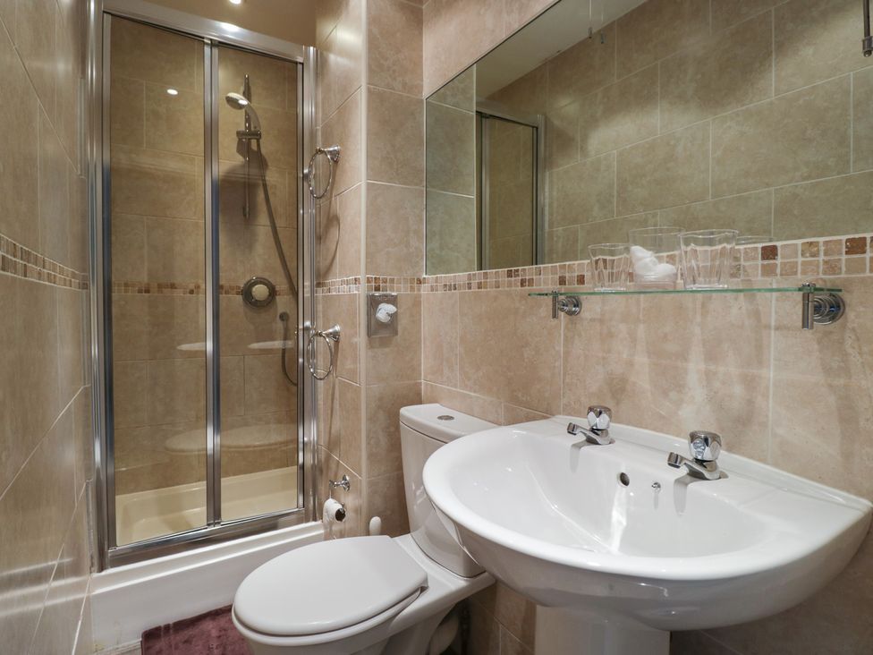 A bathroom with a shower, toilet, and sink at Norwood House in Ambleside