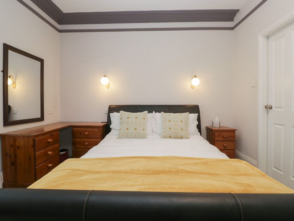A bedroom with a bed, mirror, and dresser at Norwood House in Ambleside