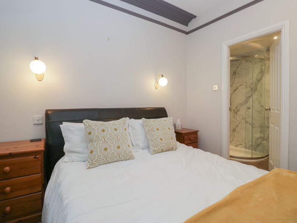 A bedroom with a bed and a shower area at Norwood House in Ambleside