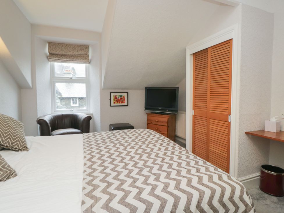 A bedroom featuring a bed, television, and drawer at Norwood House in Ambleside