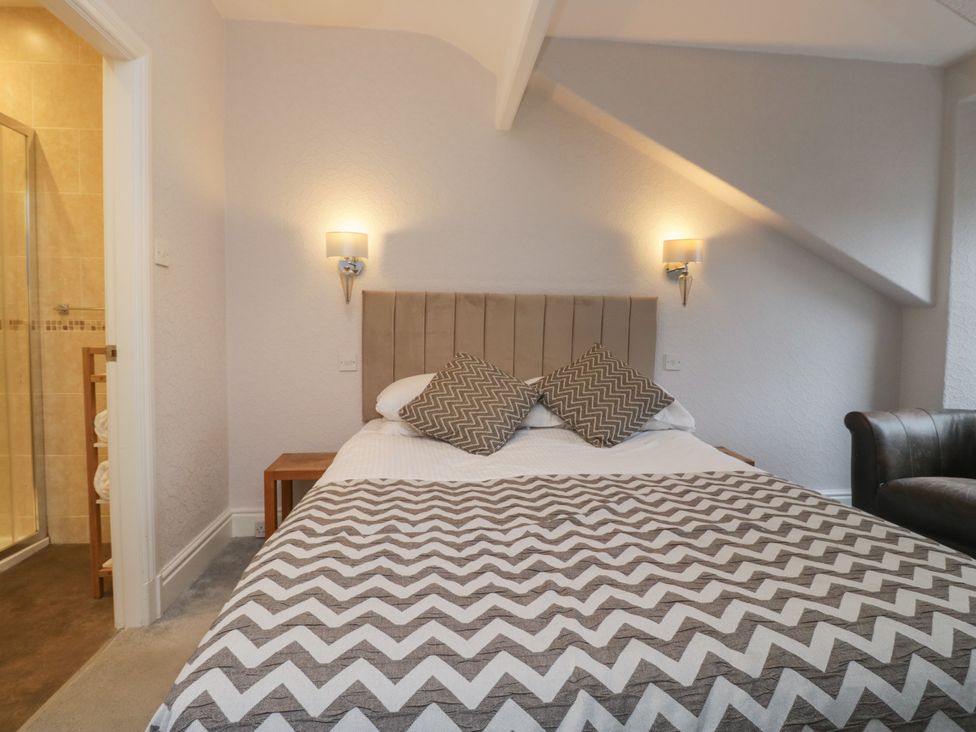 A bedroom with a bed and an adjoining shower at Norwood House in Ambleside