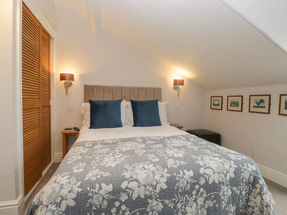 A bedroom with a bed and wall art at Norwood House in Ambleside