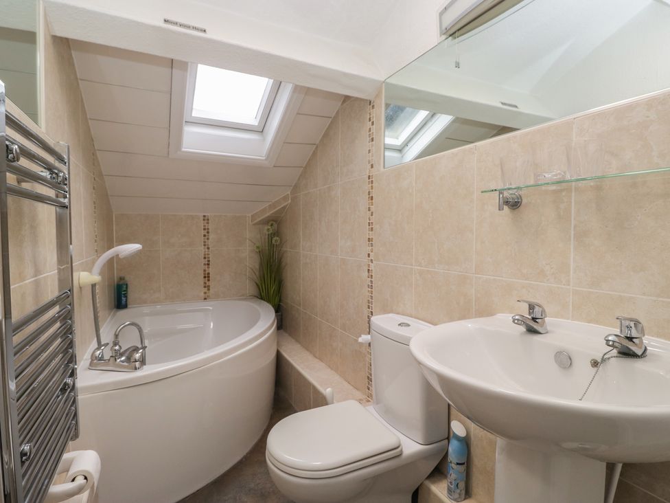 A bathroom with a bath tub, sink, and toilet at Norwood House in Ambleside