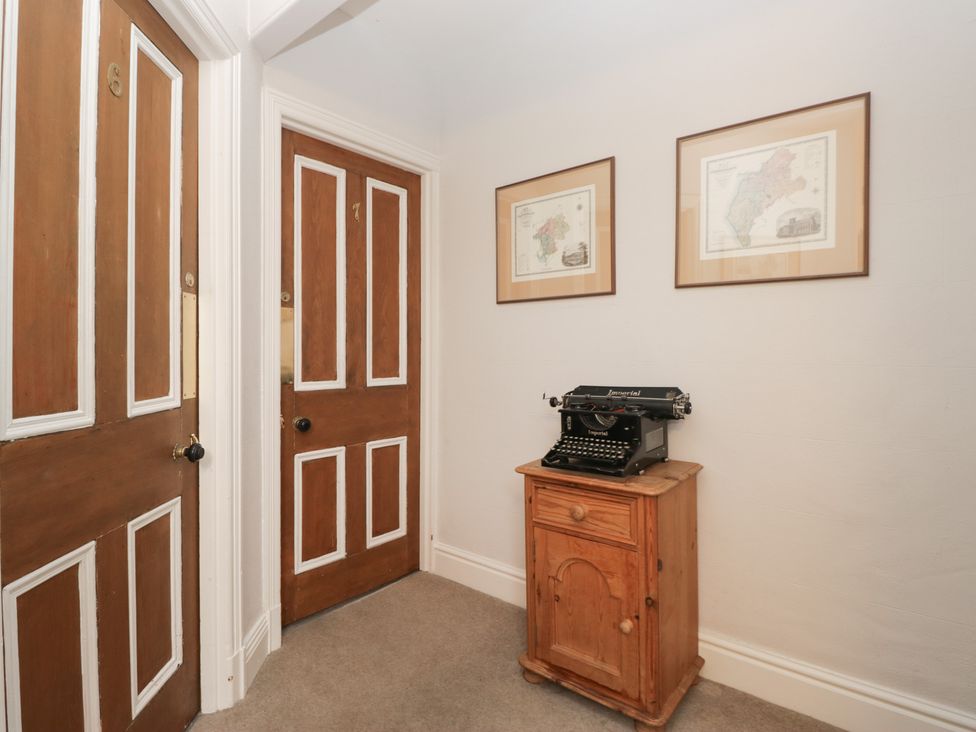 A hallway with a typewriter and wooden cabinet at Norwood House in Ambleside