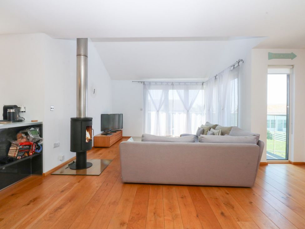 A living room with a fireplace and a sofa at Shearwater in Rhosneigr