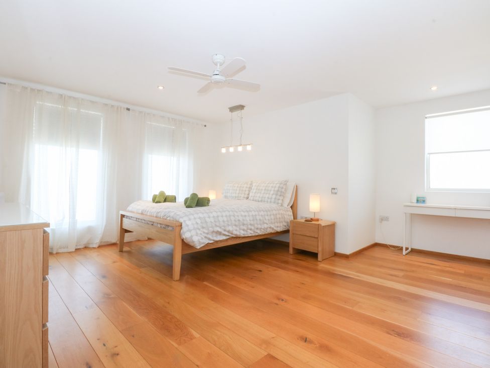 A bedroom with a bed and desk at Shearwater in Rhosneigr