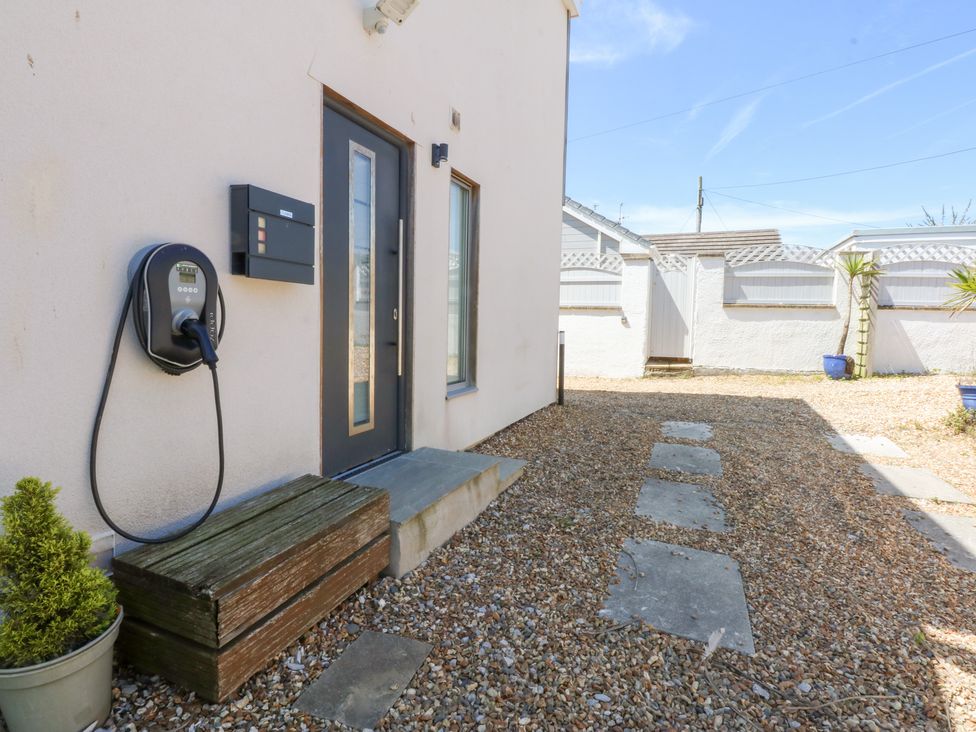 An outdoor area with an electric vehicle charger and a mailbox at Shearwater in Rhosneigr