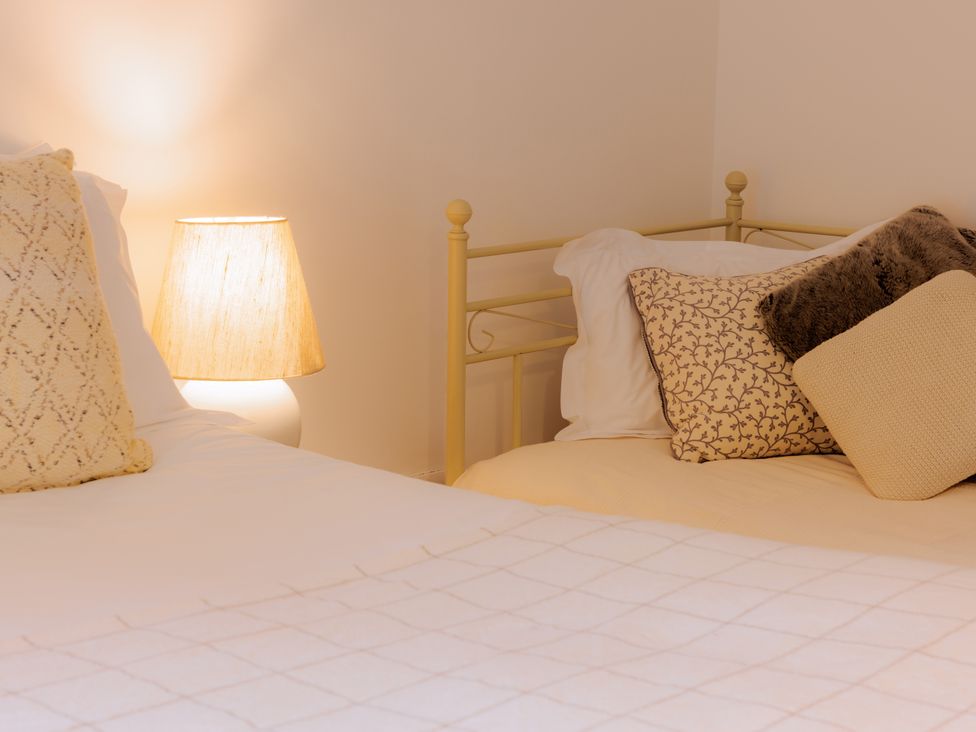 A bedroom with two beds and a lamp at Stable Cottage in Bridgnorth