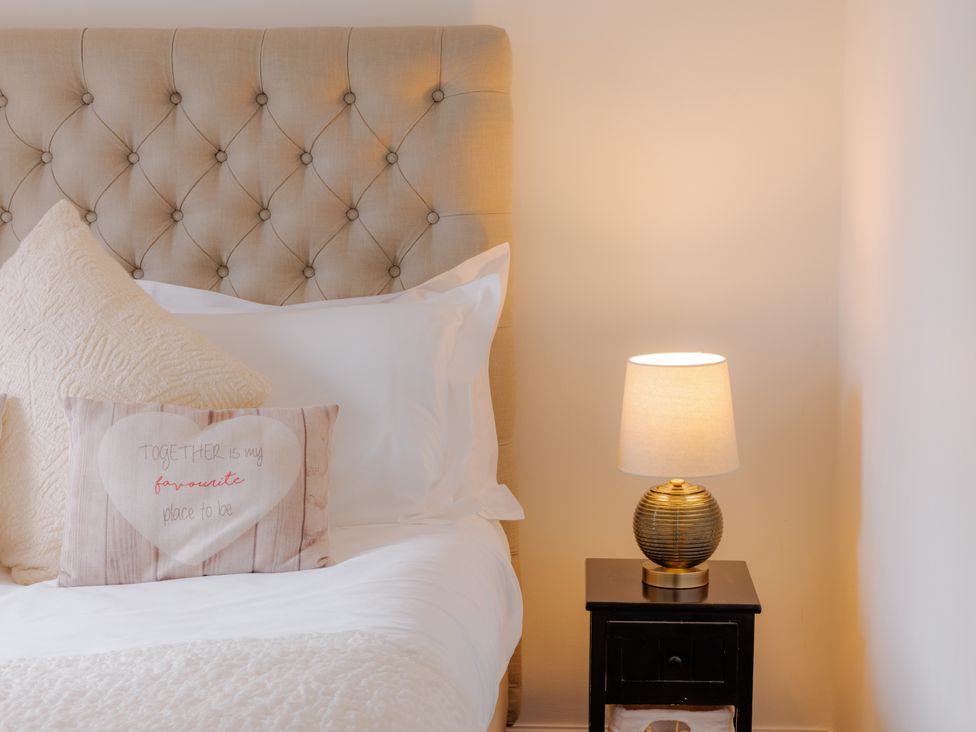 A bedroom with a bed and nightstand at Stable Cottage in Bridgnorth