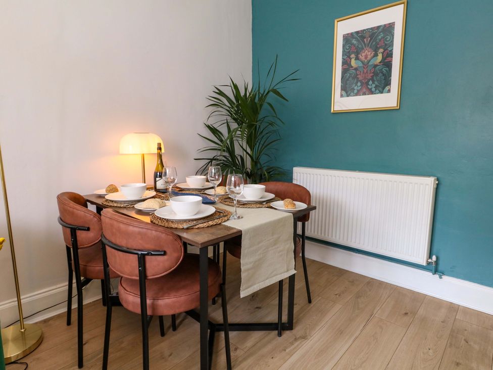 A dining table with chairs and a plant at Seagull & Chips in Weymouth