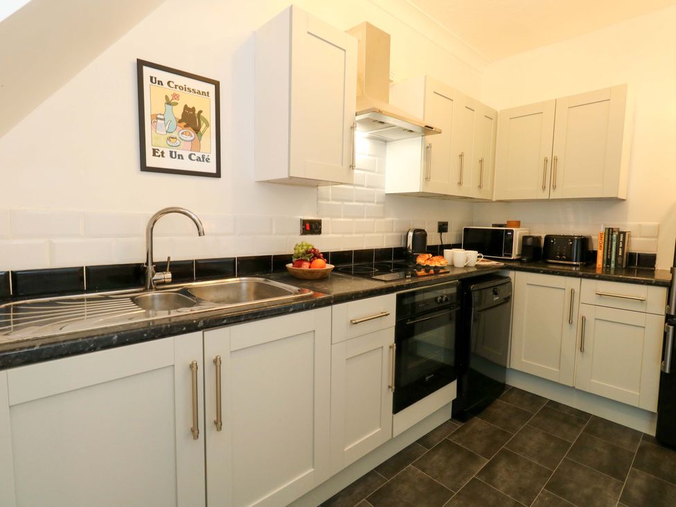 A kitchen with cabinets, appliances and a fruit bowl at Seagull & Chips in Weymouth