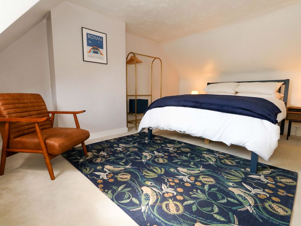 A bedroom with a bed and a chair at Seagull & Chips in Weymouth