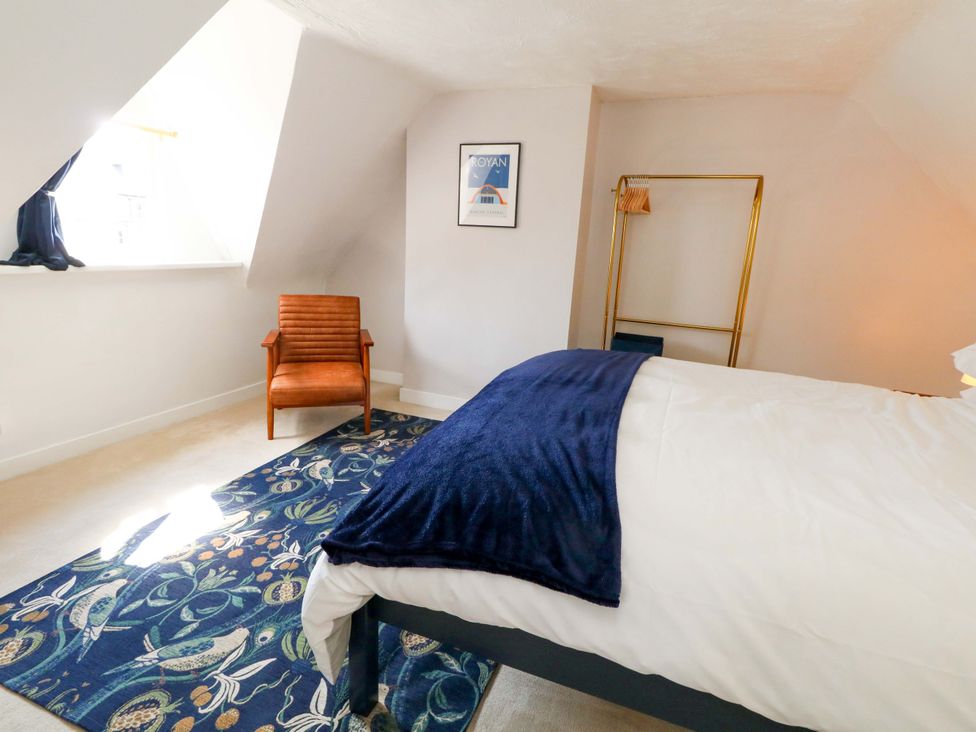 A bedroom with a bed and chair at Seagull & Chips in Weymouth