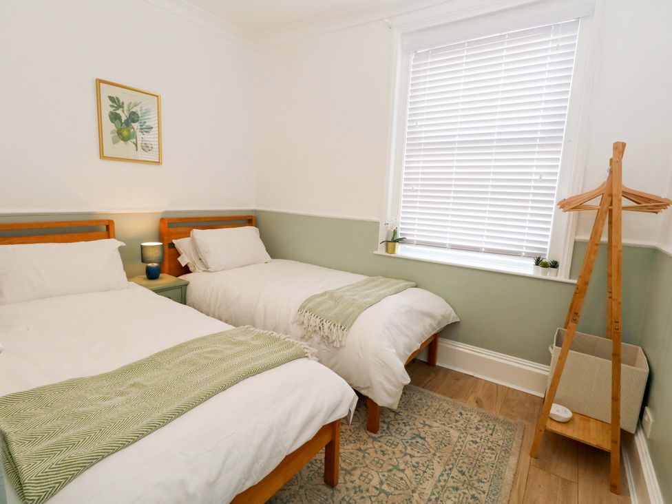 A bedroom with two beds and a lamp at Seagull & Chips in Weymouth