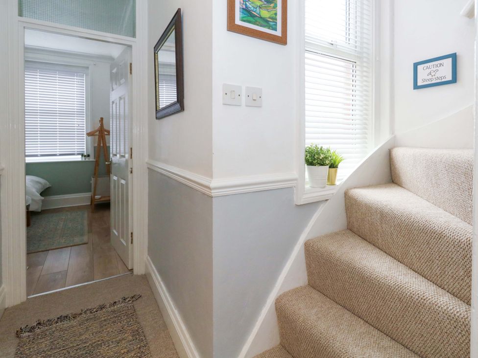 A hallway with stairs and a mirror at Seagull & Chips in Weymouth