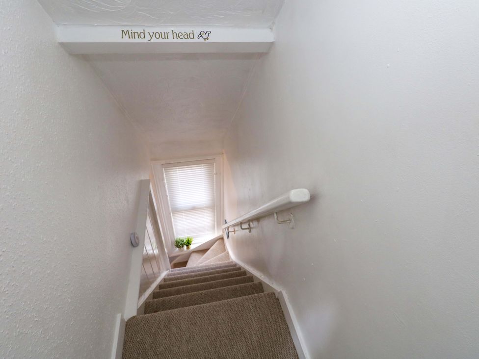 A staircase with a handrail and window at Seagull & Chips in Weymouth