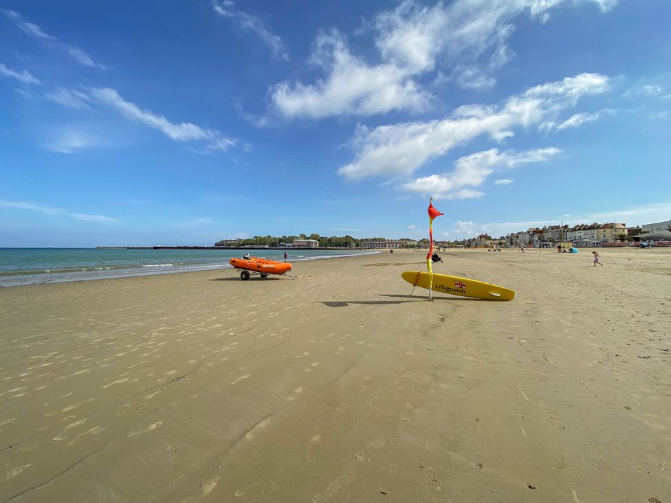 A beach with lifeguard boat and surfboard at Seagull & Chips in Weymouth