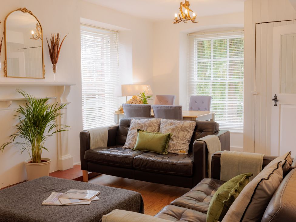 A living room with a sofa and dining area at Game Cottage in Bridgnorth