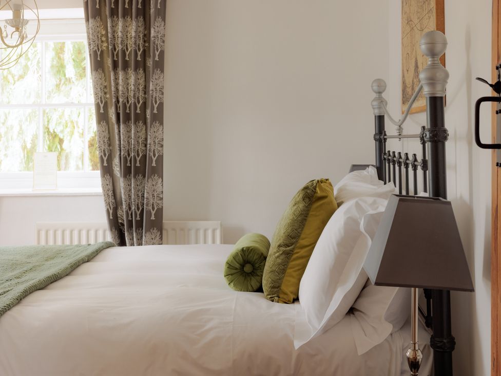 A bedroom with a bed and pillows at Game Cottage in Bridgnorth