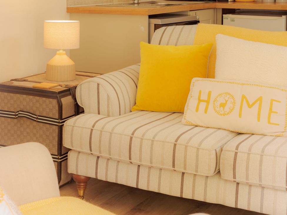 A living room with a sofa and lamp at The Bothy in Bridgnorth