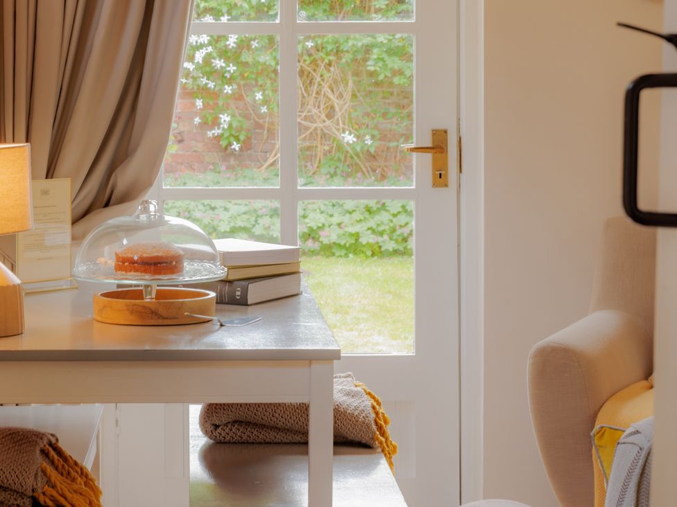 A table with a cake stand and books in a room at The Bothy in Bridgnorth