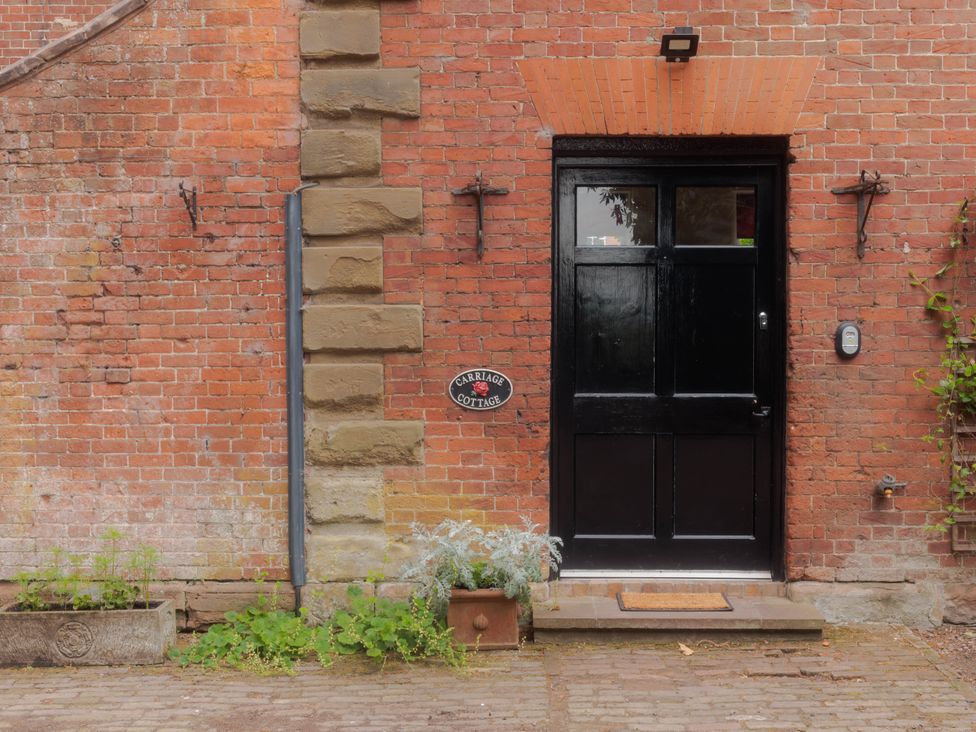 An entrance with a door and sign at Carriage Cottage in Worfield near Bridgnorth