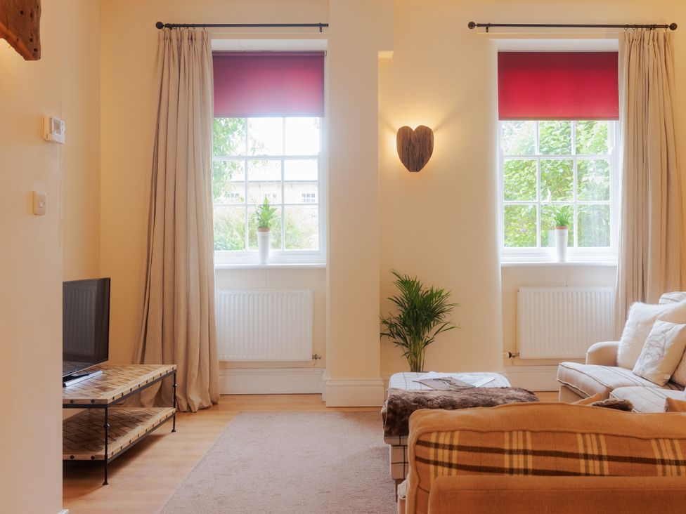 A living room with a television and sofa at Carriage Cottage in Worfield near Bridgnorth