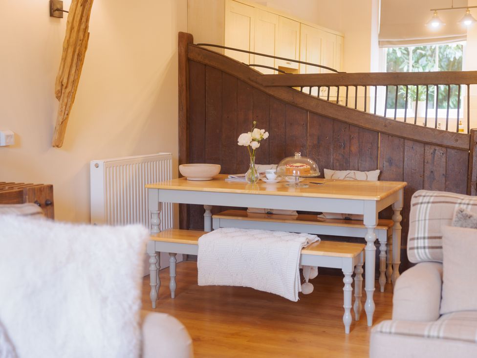 A dining area with a table and bench at Carriage Cottage in Worfield near Bridgnorth