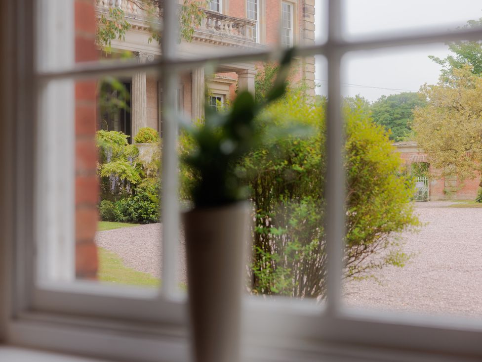 A view of a garden through a window at Carriage Cottage in Worfield near Bridgnorth