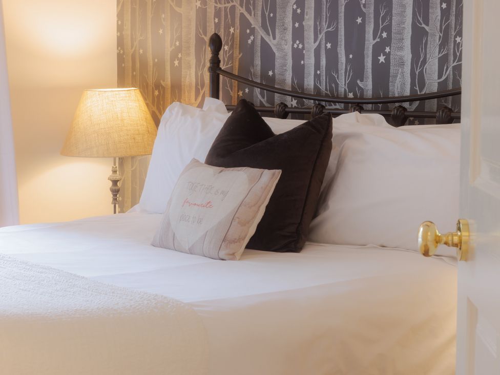 A bedroom with a bed, pillows and lamp at Carriage Cottage Worfield near Bridgnorth