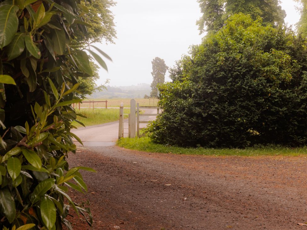 A pathway leading to a gate with greenery at Carriage Cottage in Worfield near Bridgnorth