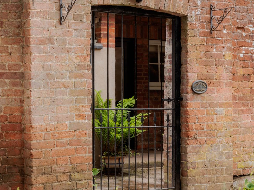 A metal gate with a fern plant visible in the doorway at Coachmans Cottage Worfield near Bridgnorth