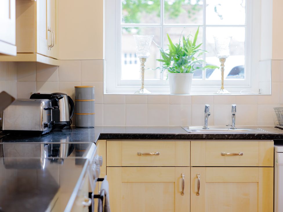 A kitchen with a sink and appliances at Coachmans Cottage in Worfield near Bridgnorth