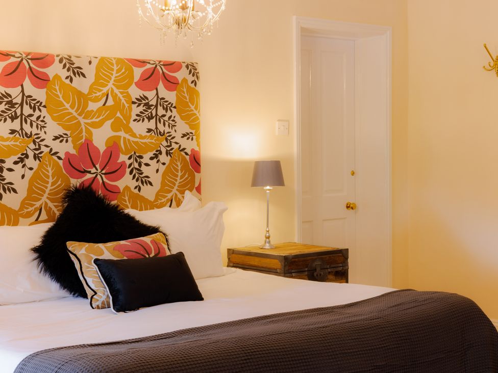 A bedroom with a bed and lamp at Coachmans Cottage in Worfield near Bridgnorth