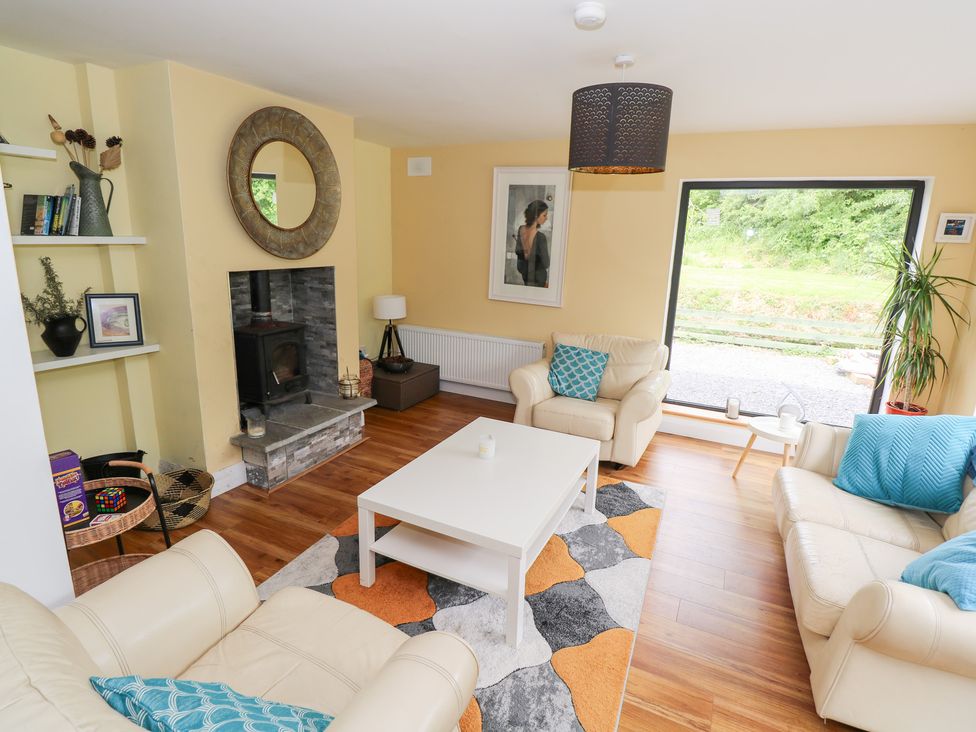 A living room with a fireplace and large window at Huath in Carrick on Shannon