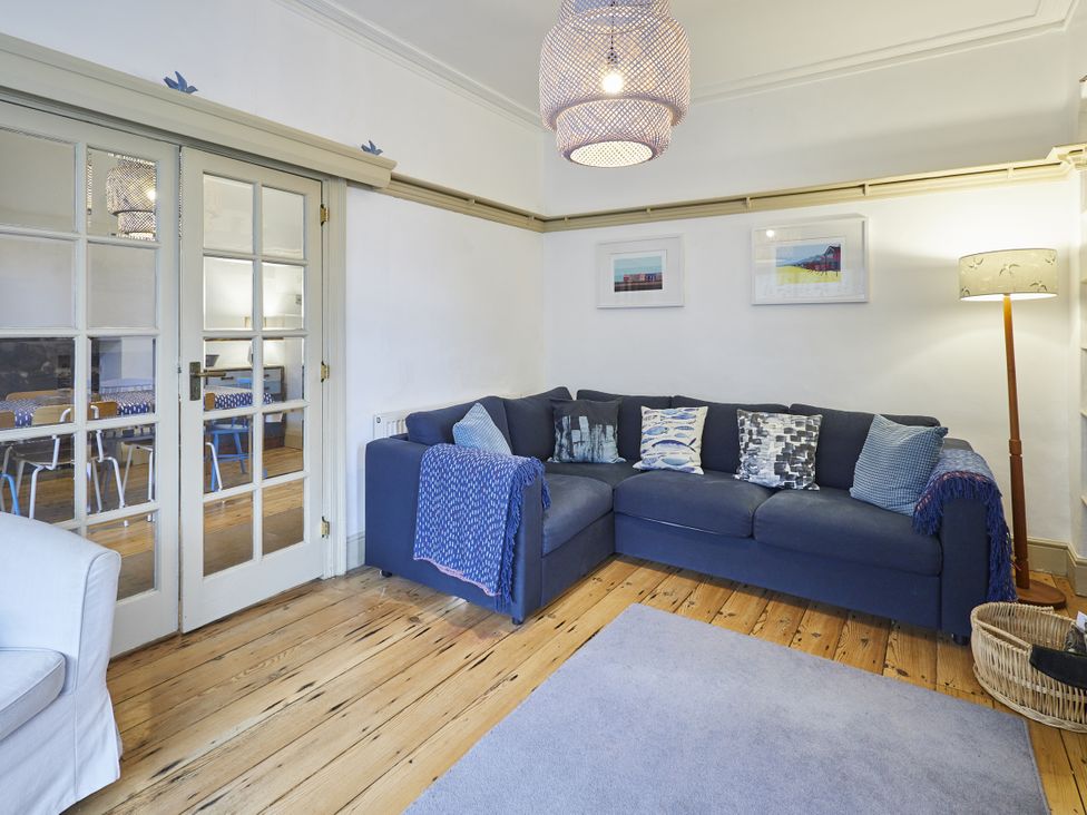 A living room with a sofa and a lamp at Beachside Cottage in Sandsend
