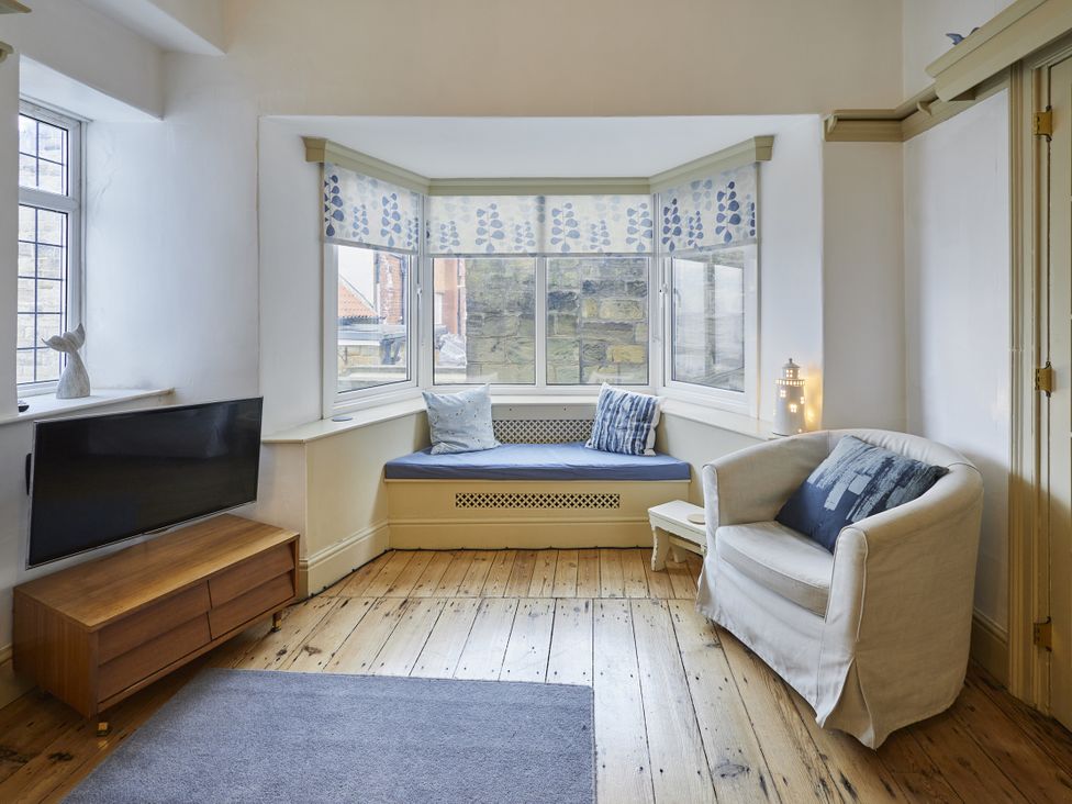 A living room with a sofa and television at Beachside Cottage in Sandsend