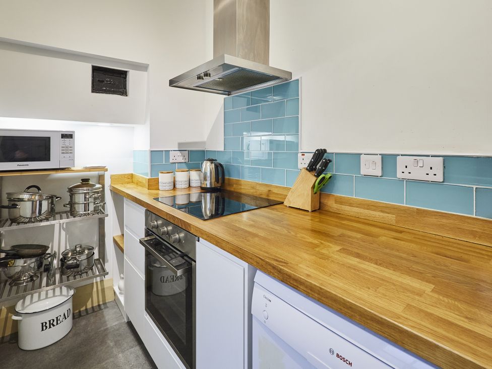 A kitchen with a countertop, microwave, and induction cooktop at Beachside Cottage in Sandsend