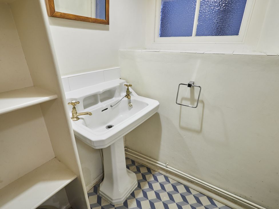 A sink and mirror in a bathroom at Beachside Cottage Sandsend