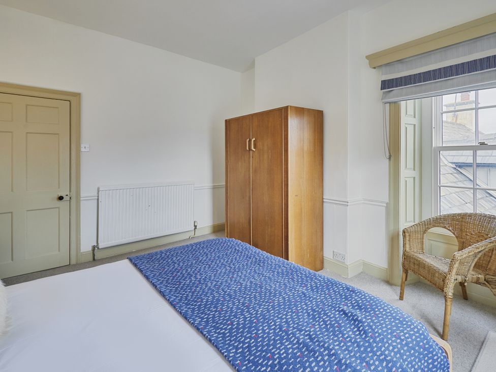 A bedroom with a bed and a wardrobe at Beachside Cottage in Sandsend