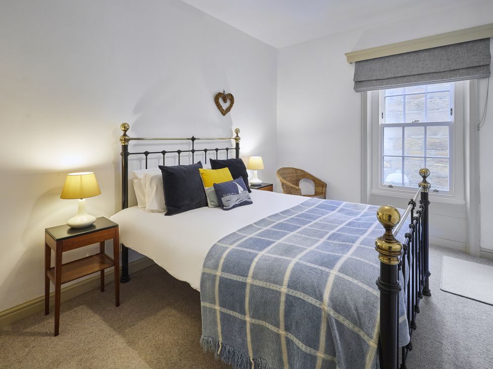 A bedroom with a bed and bedside table at Beachside Cottage in Sandsend