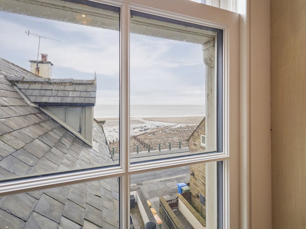 A view of the sea and beach from a window at Beachside Cottage in Sandsend