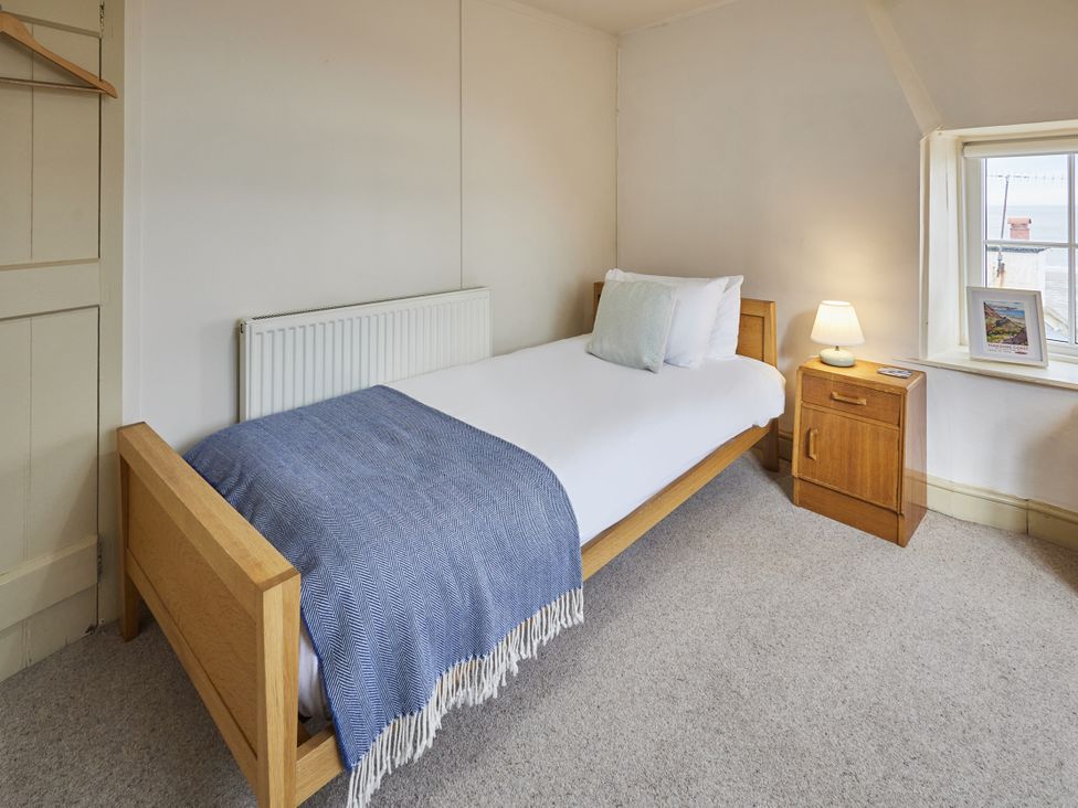 A bedroom with a single bed, nightstand and lamp at Beachside Cottage in Sandsend