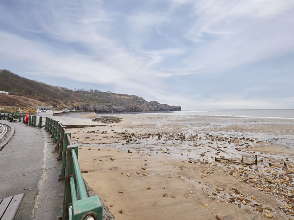 A beach with sand and rocks at Beachside Cottage Sandsend