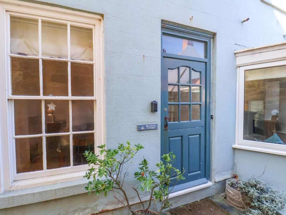 An entrance area with a blue door and windows at Beachside Cottage in Sandsend