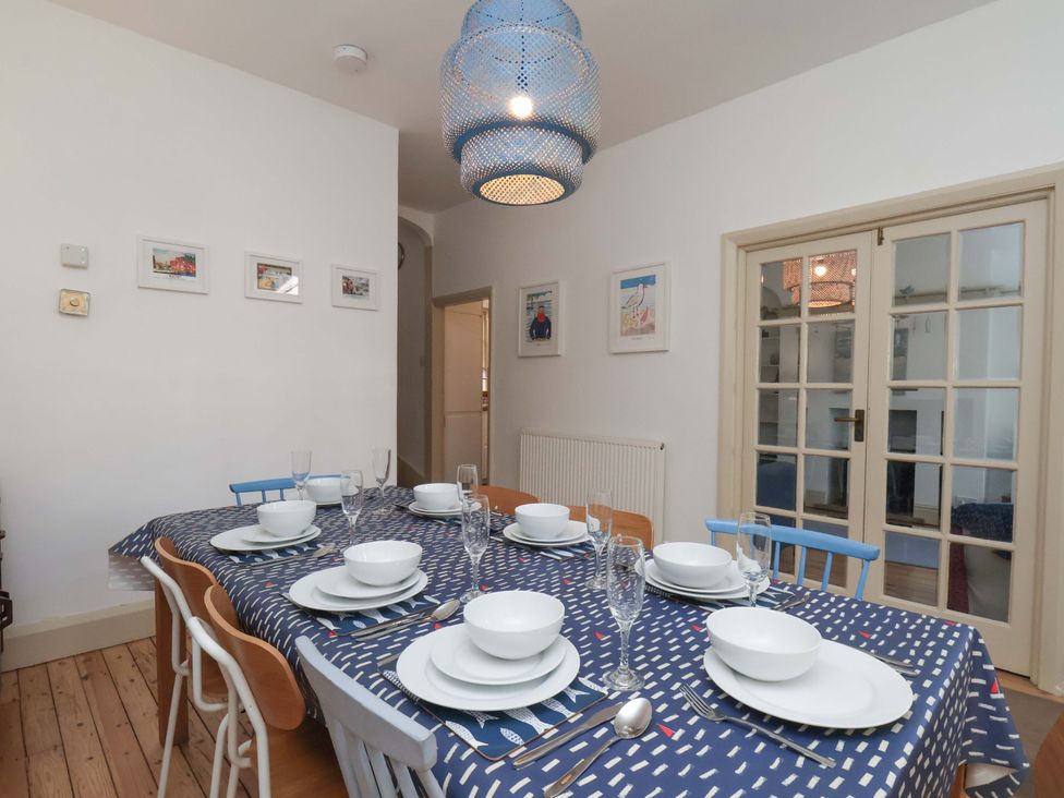 A dining room with a table set for a meal at Beachside Cottage in Sandsend